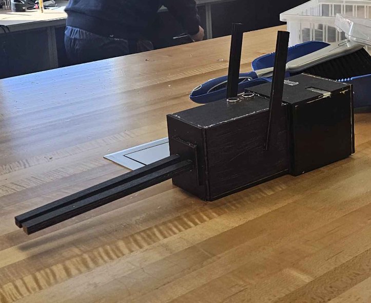 Student working at a scroll saw in the workshop with a remote control box on the table