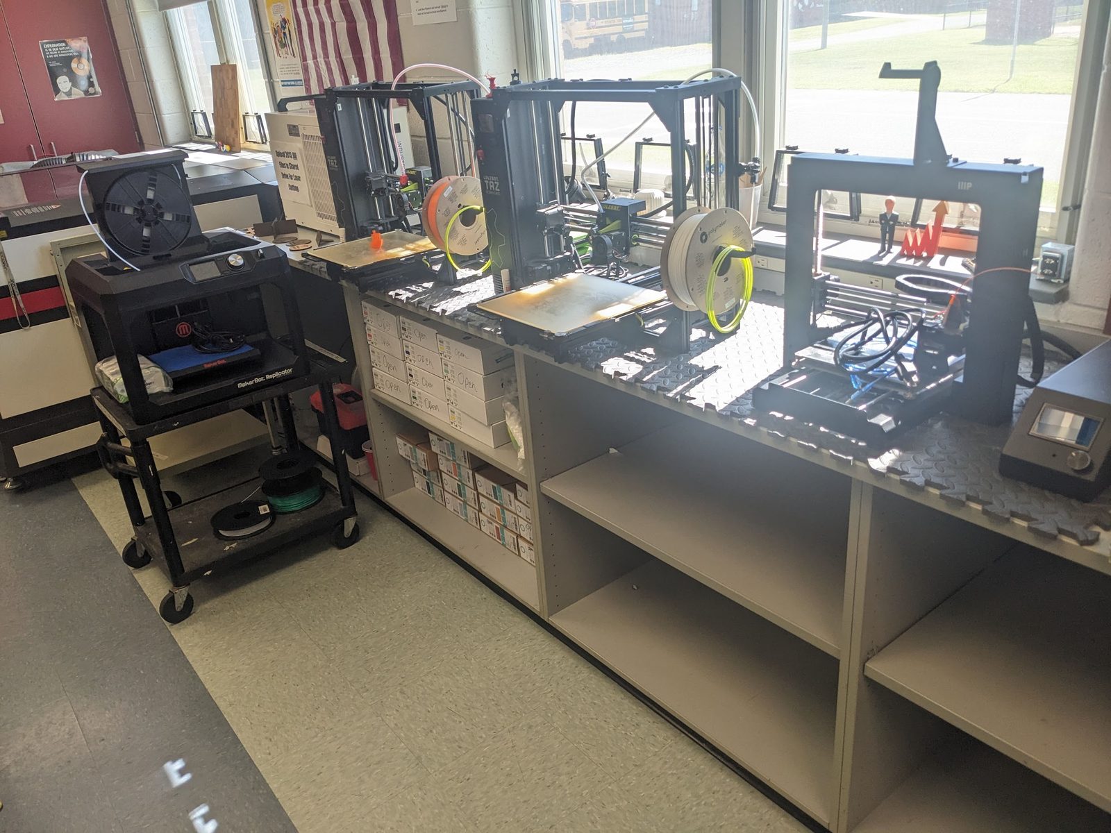 After: a lineup of 3D printers, including a MakerBot Replicator and two LulzBot TAZ machines