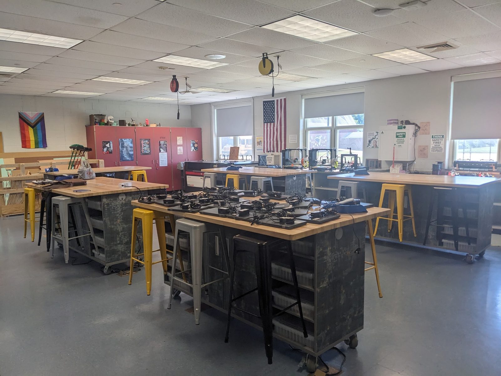 Finished engineering lab wide view with the laser cutter, 3D printer bank, and pod desks