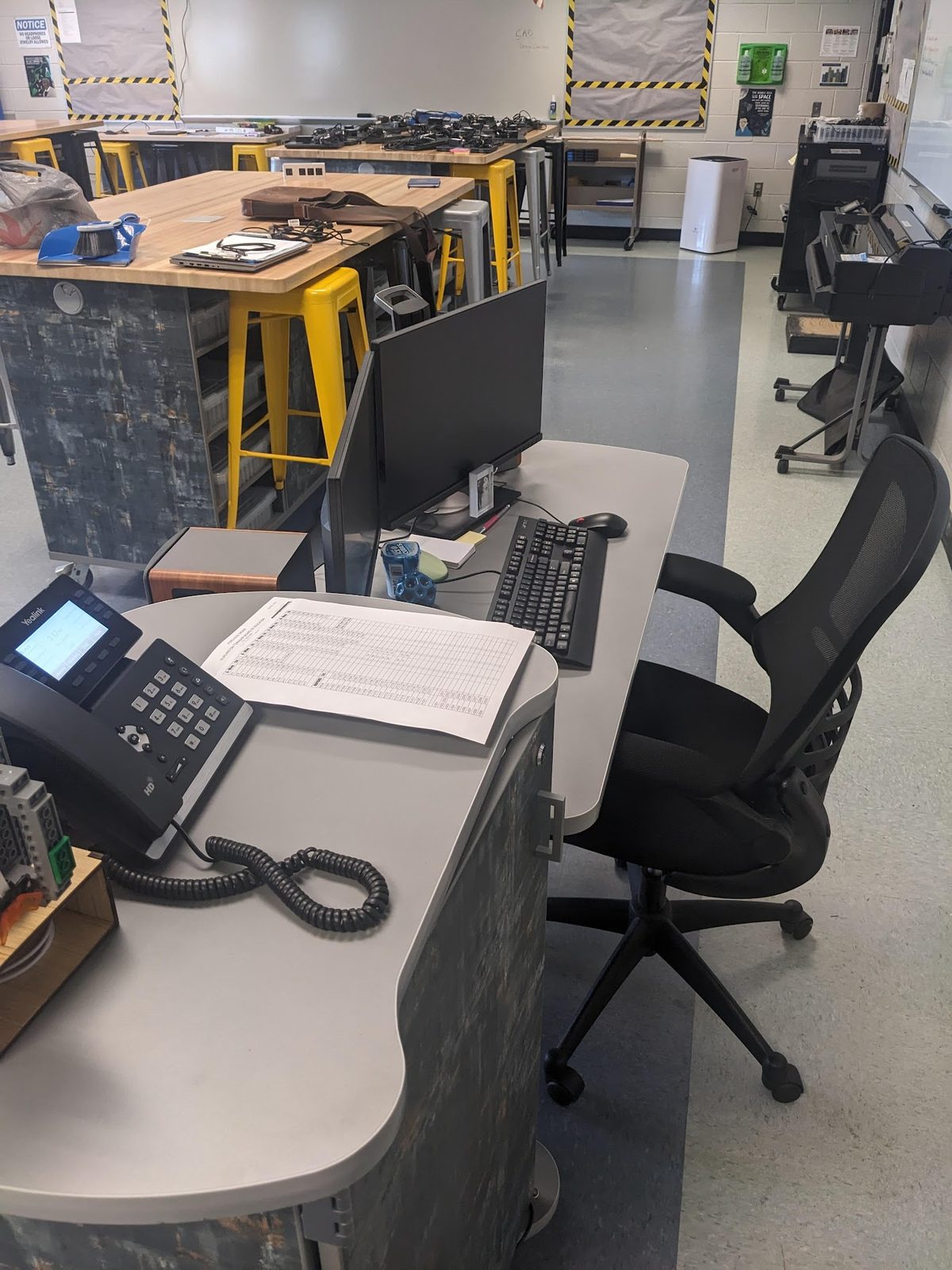 After: the teacher's desk in daily use, with monitor, keyboard, and desk phone
