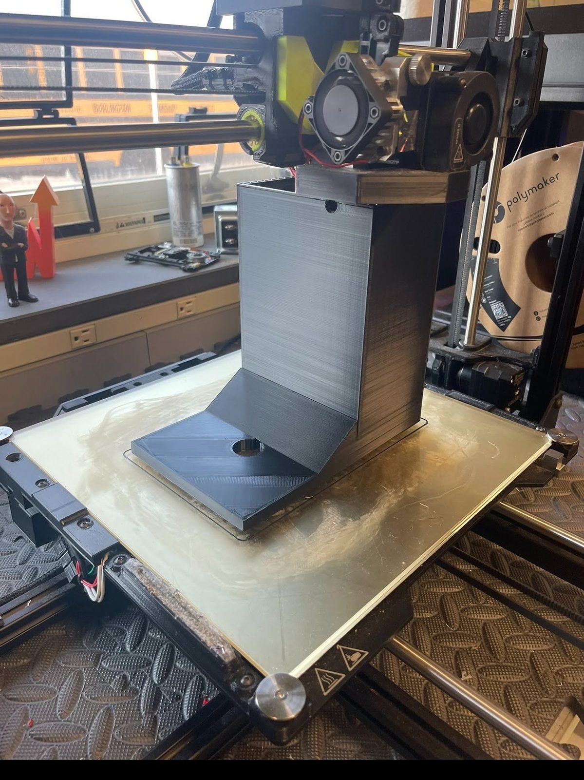 3D printer mid-print on the candle extinguisher's housing and swing arm