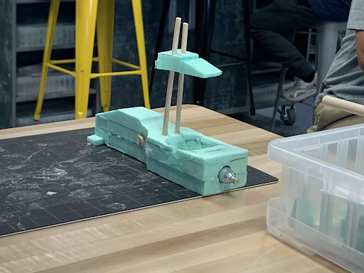 Teal foam CO2 car with an axle rod and a small vertical fin mount