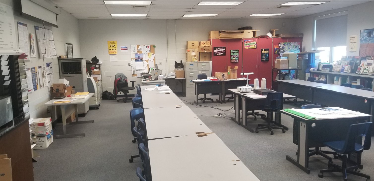 Before: the classroom from a third angle, showing a bulletin board and old teacher desk area