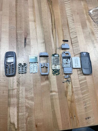 Nokia phone parts laid out in a row on a butcher-block bench