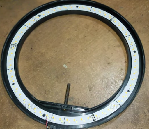 A disassembled ring light showing its circular LED circuit board
