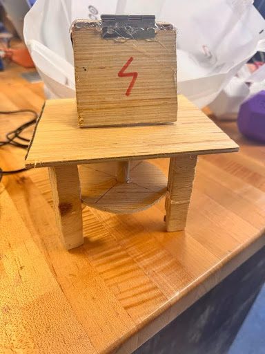 Wooden phone stand with a small table-like base and a marked block on top