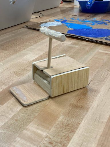 Phone stand with a dowel hook mechanism and a removable base piece