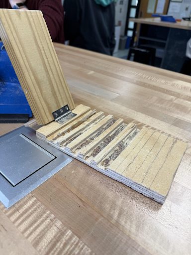 Fold-out phone stand made of thin plywood slats on a hinge