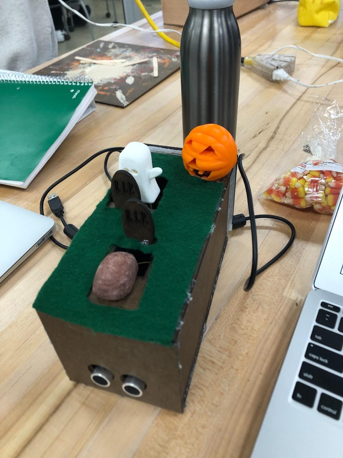 Halloween graveyard-themed animatronic box with a ghost, jack-o'-lantern, and ultrasonic sensors