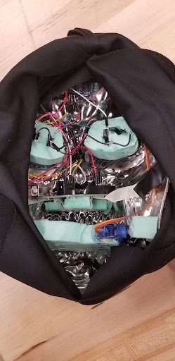 Inside view of the chrome skeleton mask showing its wiring, servo, and electronics