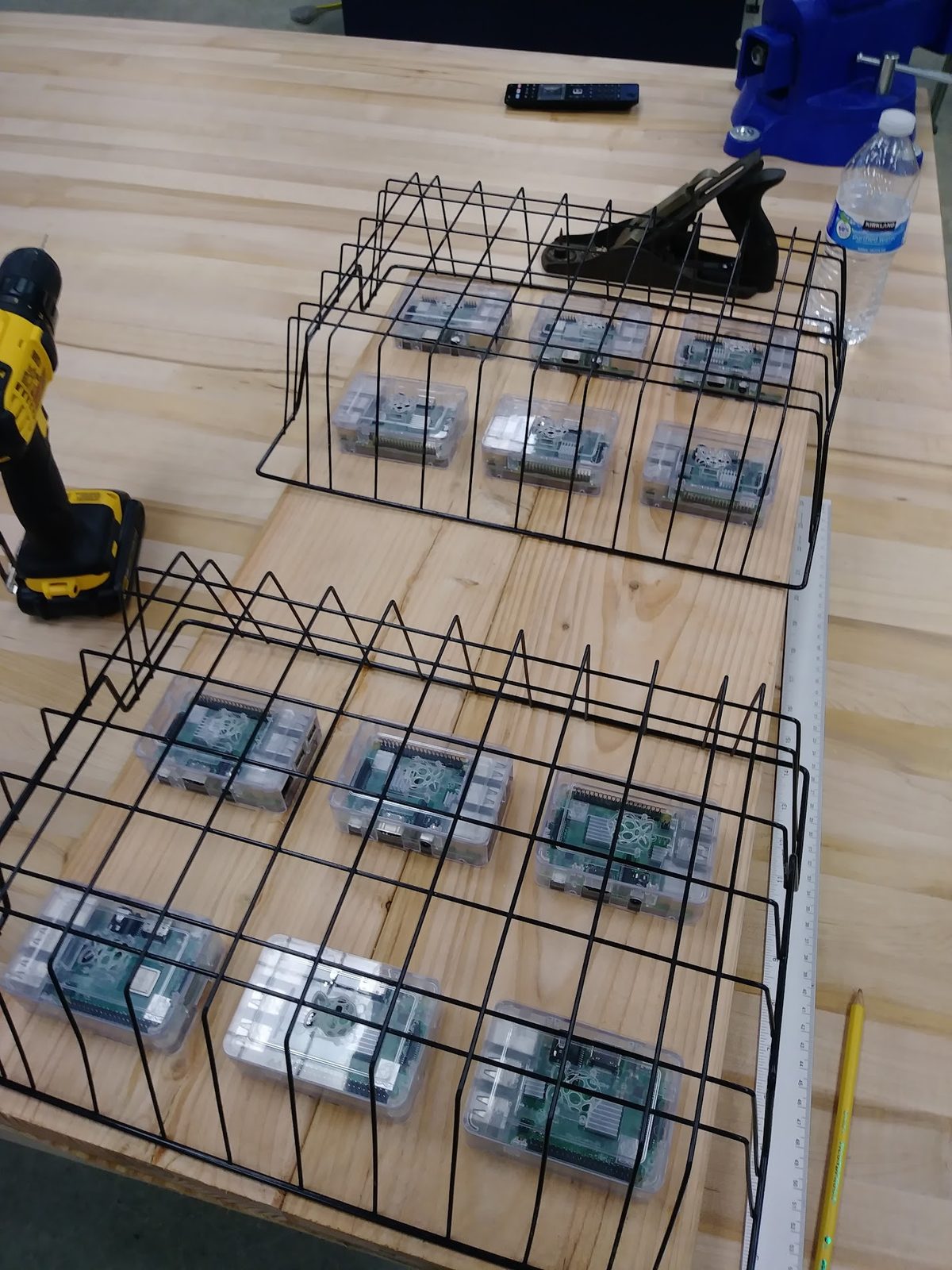 Raspberry Pis being seated into wire racks on a workbench during the mount build