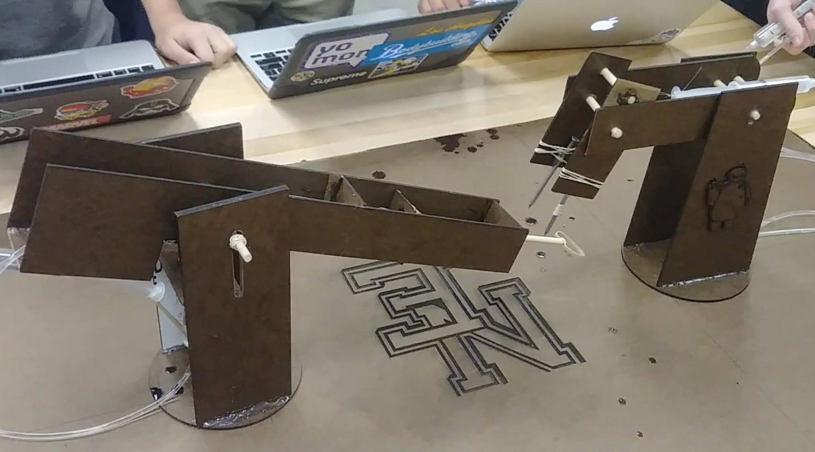 Laser-cut battlebot chassis with pneumatic cylinder arms, engraved with the New Egypt Warriors logo