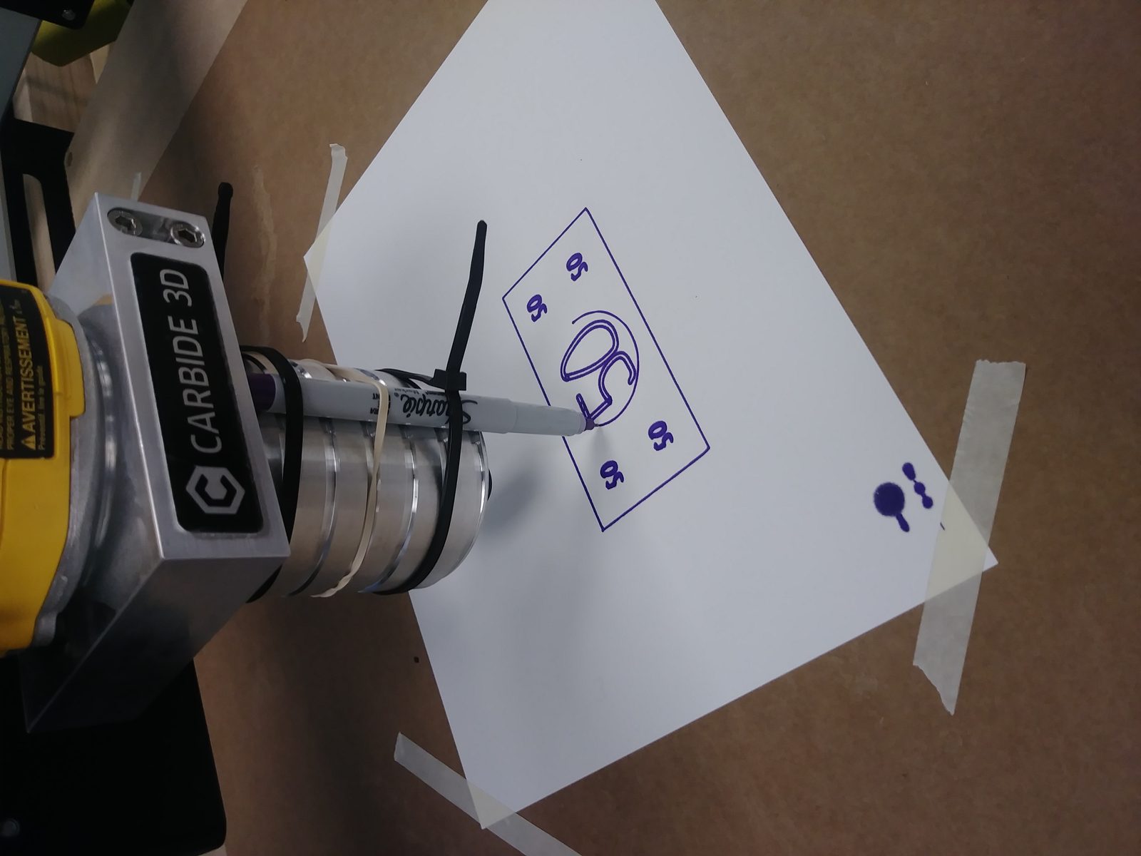 Carbide 3D CNC machine holding a Sharpie, plotting a logo design onto paper