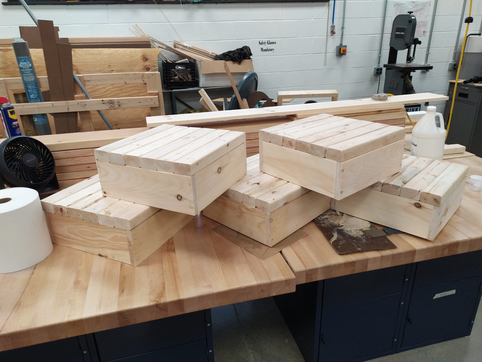 Multiple identical unstained wood-plank boxes built in the shop using the same jig
