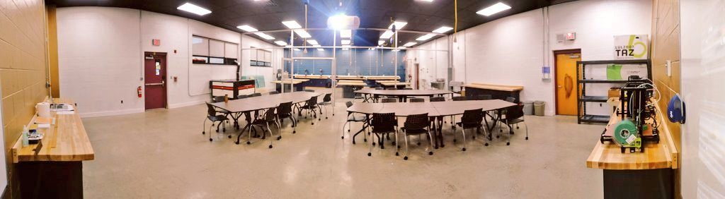 Finished lab with rows of tables and chairs for classroom instruction, plus a 3D printer station
