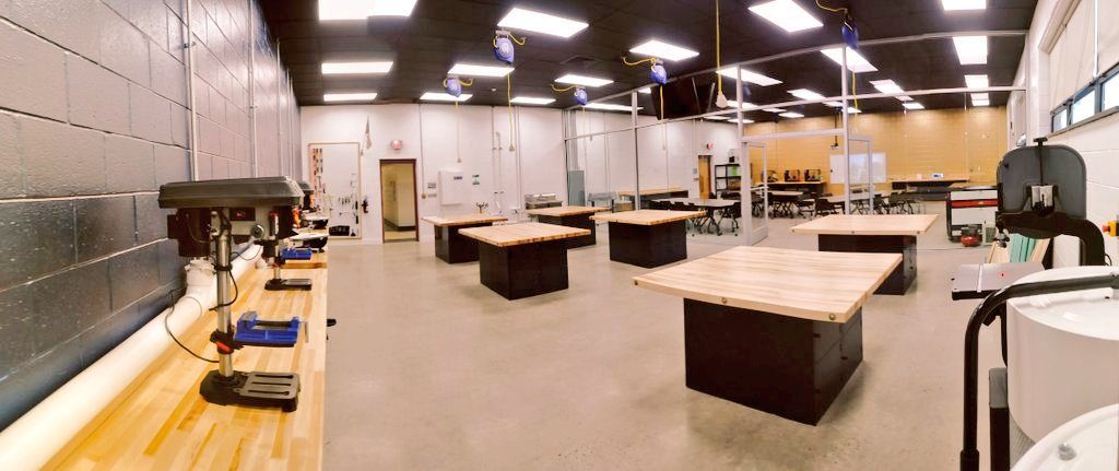 Finished lab fabrication area with a drill press, workbenches, and a band saw