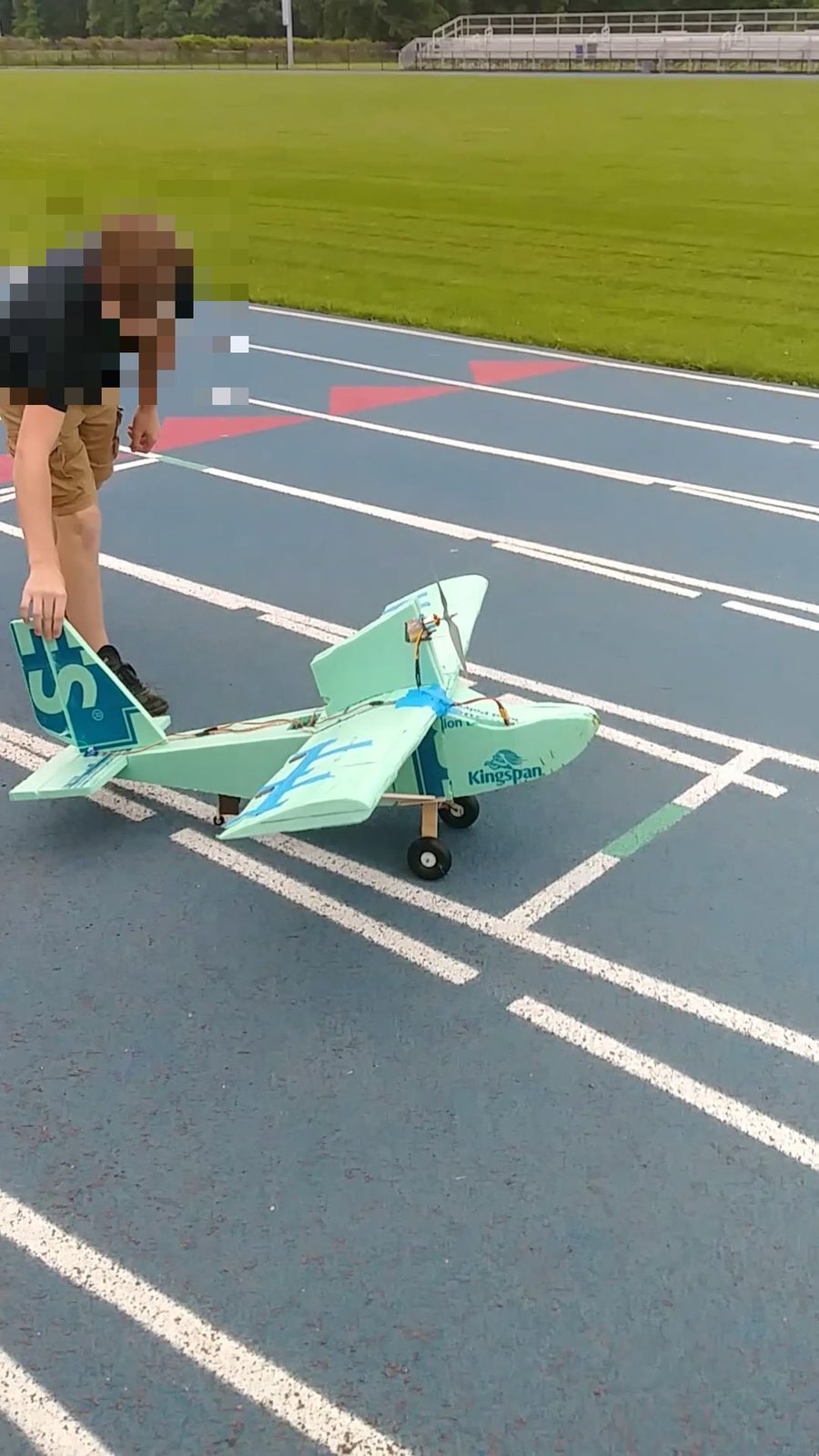 Student preparing the finished foam RC plane for a test flight on the school track
