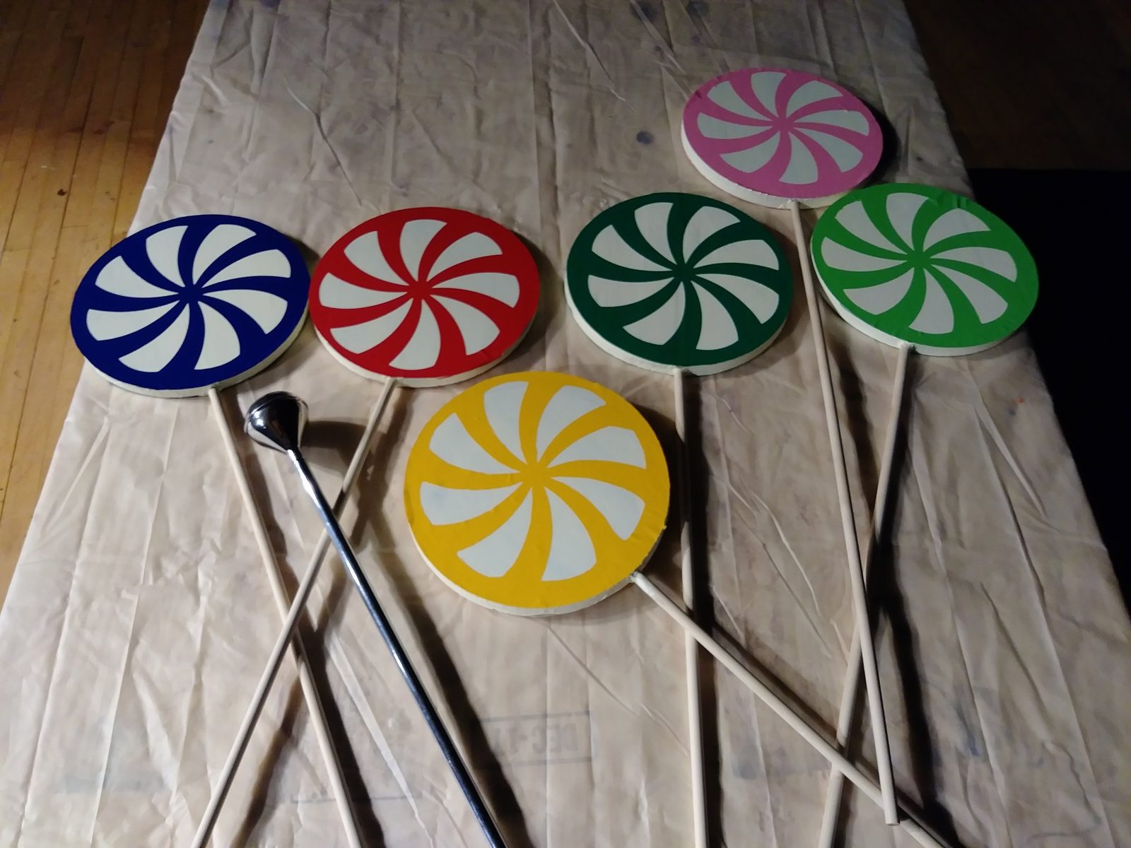 Six oversized painted lollipop props laid out on a drop cloth