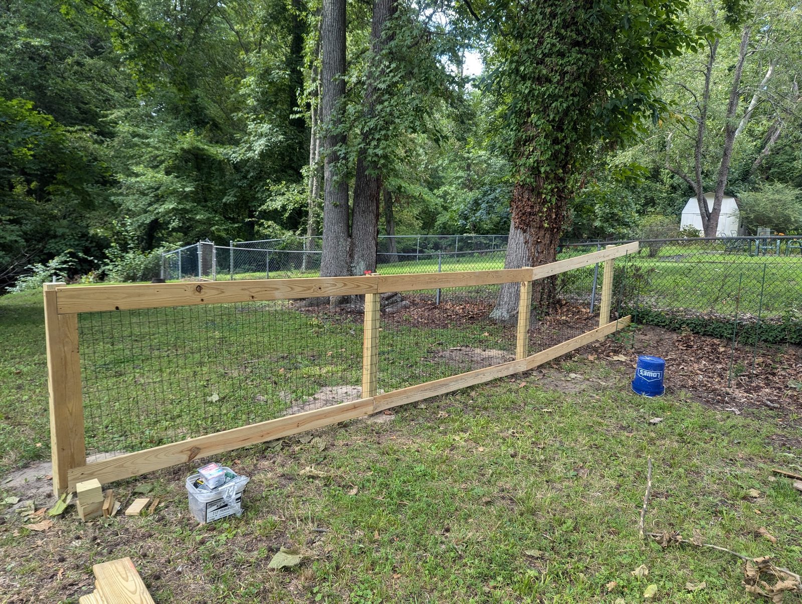 Wood-framed wire fence stretching across the backyard