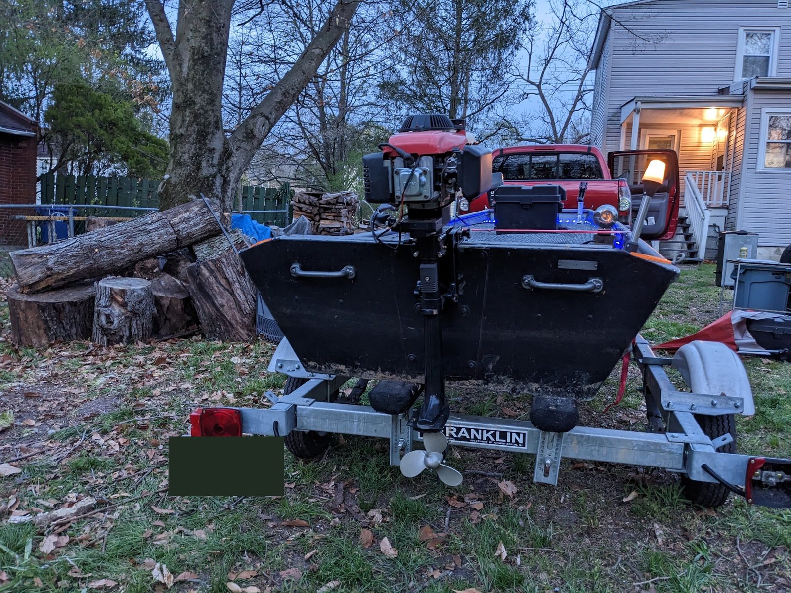 Bigger outboard motor mounted on the transom, dusk in the driveway