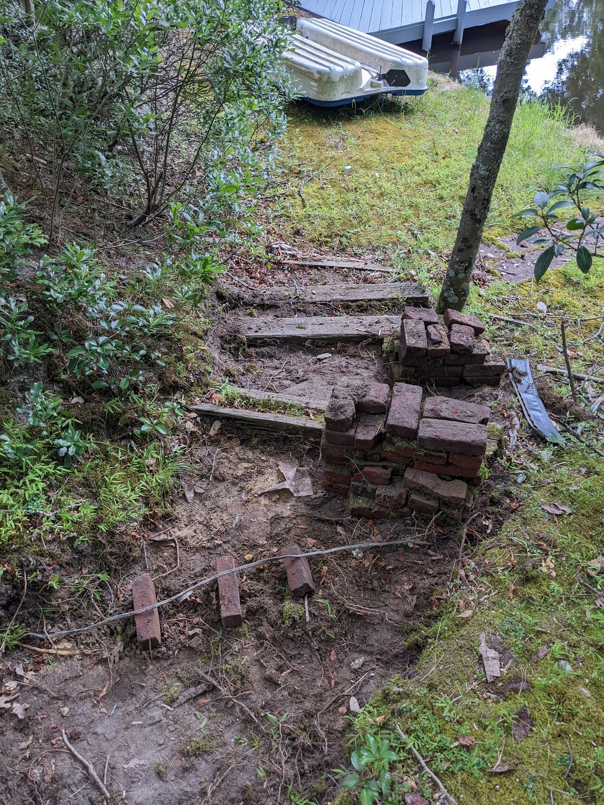 Wood step borders pried up for rework partway down the slope