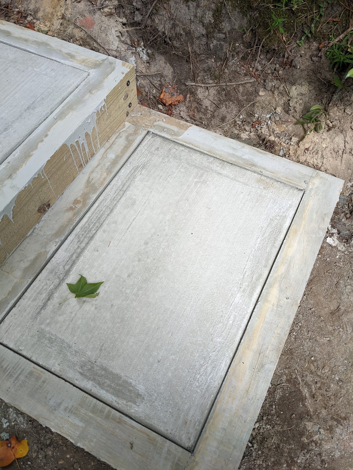New step with hand-poured concrete set inside its stained wood border