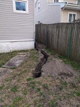 Freshly dug drainage trench along the side yard fence line