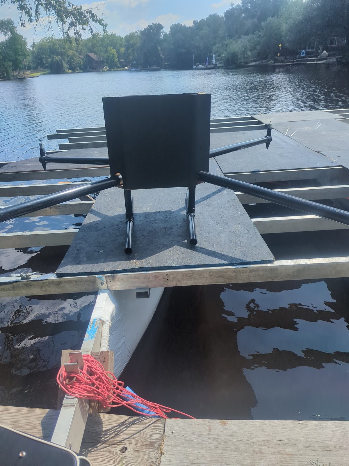 Float frame set up at the water's edge, dock and lake behind it