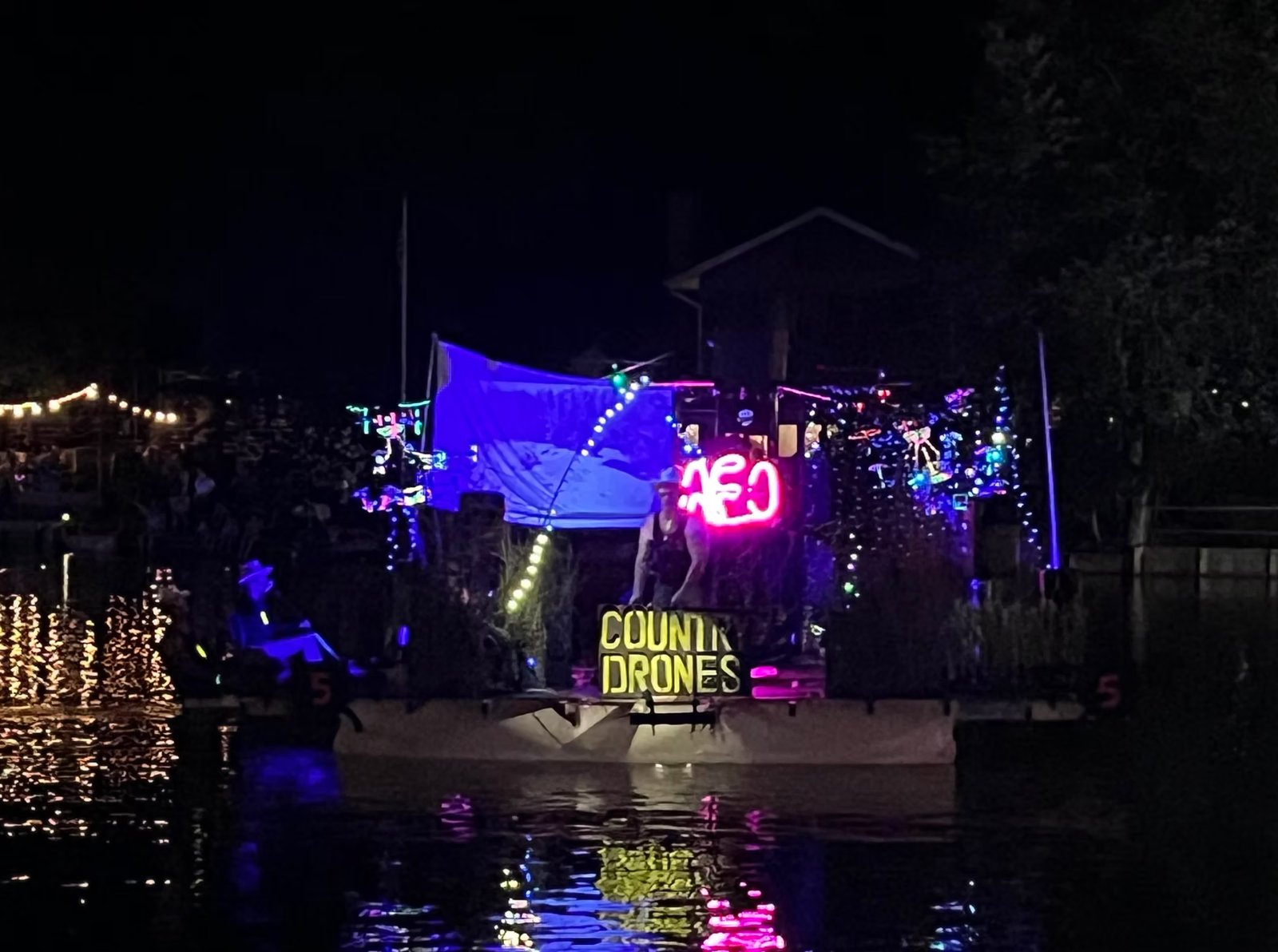 Finished float fully lit at night, cruising the water during the carnival