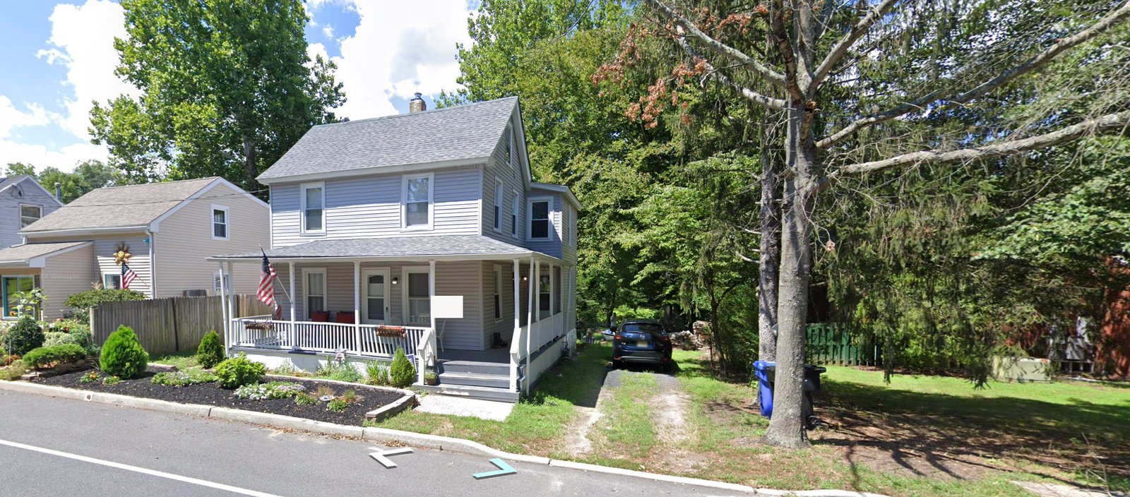 The house as we inherited it, open front porch, car in the driveway, view from the street