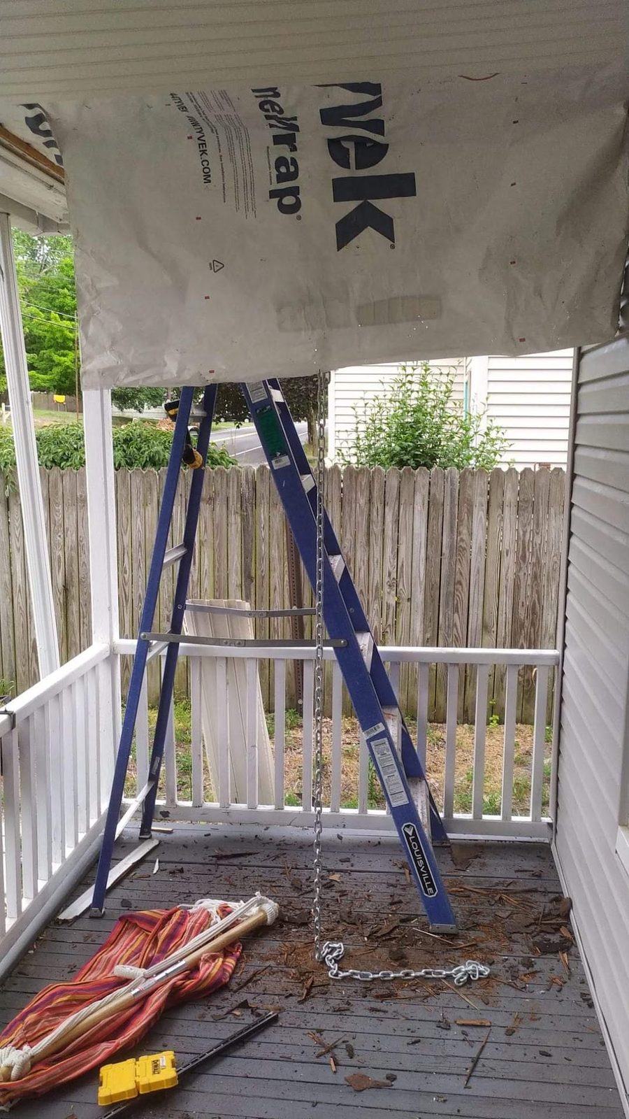 Ladder and tools set up on the front porch during a repair
