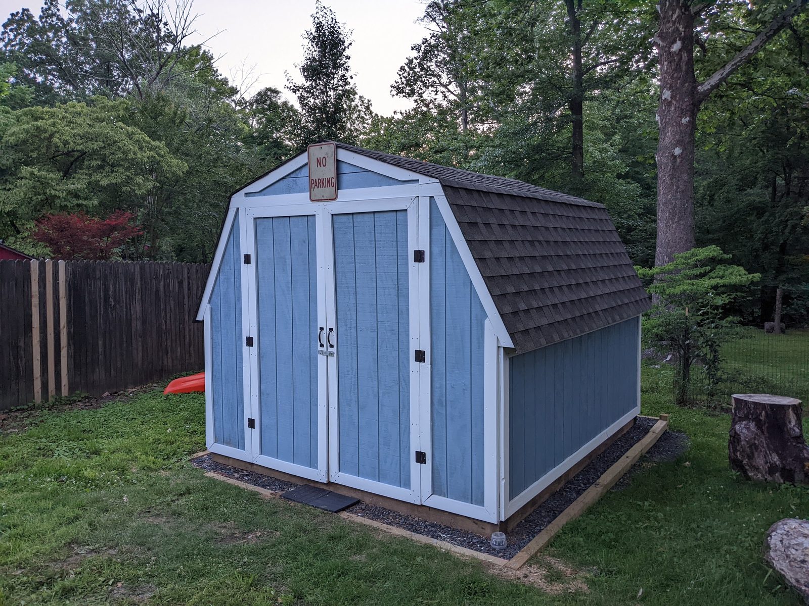 Finished blue shed with dark shingled roof, front three-quarter view